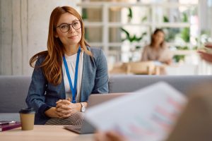 Das Bild zeigt eine junge Frau Mitte Dreißig im Gespräch zur Unternehmensübergabe mit Unterstützung in der Finanzierung durch die Bürgschaftsbank Brandenburg.